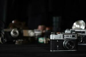 KHARKOV, UKRAINE - APRIL 27, 2021 Fed 4 and 5b Film photo camera and another old retro photo equipment on black wooden table in photographer darkroom. Photographic gear from soviet union