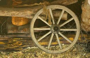 The old wooden wheel from the carriage hangs on the wall of the Ukrainian barn photo