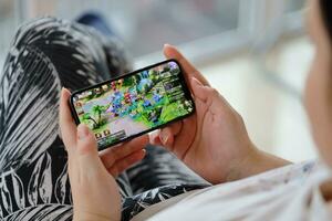 Fantasy Westward Journey mobile iOS game on iPhone 15 smartphone screen in female hands during mobile gameplay photo