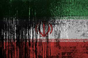 Iran flag depicted in paint colors on old and dirty oil barrel wall closeup. Textured banner on rough background photo