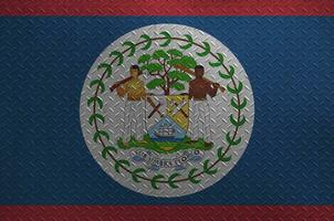 Belize flag depicted in paint colors on old brushed metal plate or wall closeup. Textured banner on rough background photo