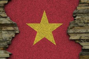 Vietnam flag depicted in paint colors on old stone wall closeup. Textured banner on rock wall background photo