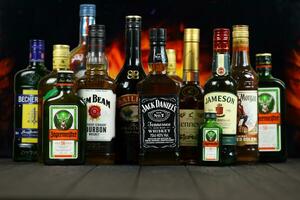 KYIV, UKRAINE - MAY 4, 2022 Many new bottles of worldwide popular alcohol brands of whiskey cognac photo