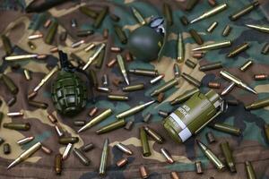 Different types of ammunition on a camouflage background. Preparing for war photo