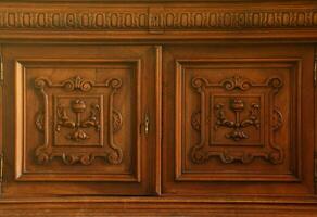 Old vintage wardrobe furniture with ornamental doors and retro colors of wooden surfaces photo