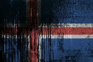 Iceland flag depicted in paint colors on old and dirty oil barrel wall closeup. Textured banner on rough background photo