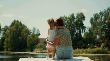 Vamos en todas partes.a pequeño hija abrazos su madre en el muelle. video