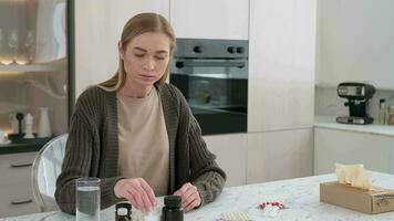 A woman reads the instructions for using medications and washes down the tablet with water. video