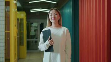 porträtt av en eleganta asiatisk företag kvinna stående i de korridor med en mapp av dokument i henne händer.annorlunda raser, olika människor, kreativa team, företag partners video