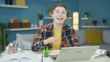 Student studying at home waving at camera. Positive expression. video