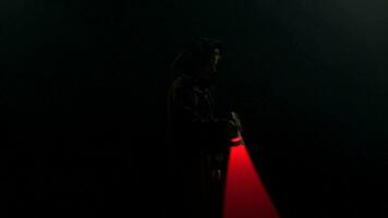joven hombre en cosplay disfraz con sable de luz batalla en negro antecedentes en fumar y lluvia, 4k lento movimiento vídeo filmado en 8k cámara Nikon z9 video