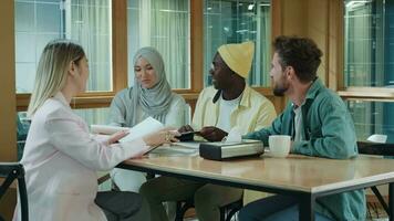 Multi-éthnique affaires équipe de collègues de travail discuter une projet tandis que séance à le bar pendant déjeuner.différent courses, diverses les gens, créatifs équipe, entreprise les partenaires video