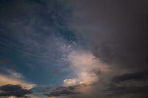 Blue violet red sunset sky background with evening curly rolling clouds may use for sky replacement photo