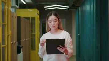 A creative stylish Asian business woman walks down the corridor with a folder of documents in her hands.Different Races,Diverse People,Creative Team,Business Partners video