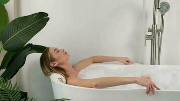 une femme prend une une baignoire et se détend. video