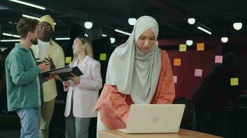 musulman affaires femme travail dans le Bureau en utilisant une ordinateur portable.différent courses, diverses les gens, créatifs équipe, entreprise les partenaires video