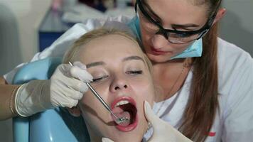 Dental specialist examines upper incisors of the patient at the dentist cabinet video