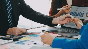 Two creative business people meeting and planning use post it notes sticky note on desk to share idea, Analysis data chart and graph with teamwork strategy brainstorming in office. video