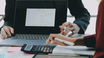 två kreativ företag människor möte och planera använda sig av posta den anteckningar klibbig notera på skrivbord till dela med sig aning, analys data Diagram och Graf med lagarbete strategi brainstorming i kontor. video