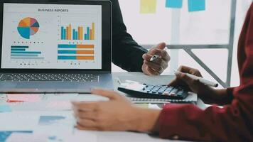 Two creative business people meeting and planning use post it notes sticky note on desk to share idea, Analysis data chart and graph with teamwork strategy brainstorming in office. video