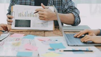 Two creative business people meeting and planning use post it notes sticky note on desk to share idea, Analysis data chart and graph with teamwork strategy brainstorming in office. video