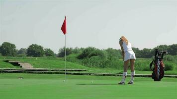 Woman stroke the ball into the hole at the golf video