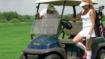 homme et femme asseoir dans le golf Chariot video