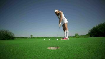 Woman hits three balls at the golf video