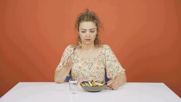 Person looking at vegetable on fork with unhappy expression. Difficulty dieting. video