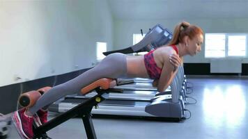 Woman trains lower back muscles at the fitness centre video