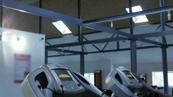 Woman puts earphones in her ears on treadmill at the fitness centre video