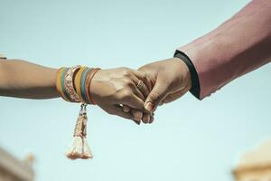 Multiracial couple holding hands together in love. Conceptual image of world unity interracial love and understanding in tolerance and diversity. photo