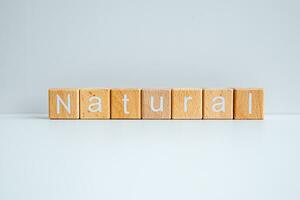 Wooden blocks form the text Natural against a white background. photo