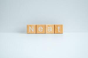 Wooden blocks form the text Neat against a white background. photo