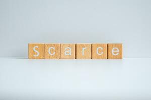 Wooden blocks form the text Scarce against a white background. photo