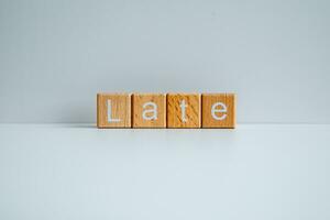 Wooden blocks form the text Late against a white background. photo