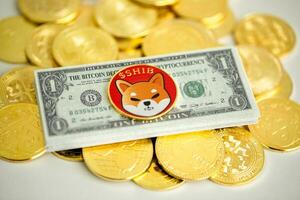 1 Shiba inu coin SHIB placed on a Bitcoin banknote with many crypto coins spread on a white background, Close up, Crypto concept. photo