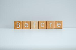 Wooden blocks form the text Before against a white background. photo