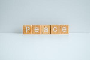 Wooden blocks form the text Peace against a white background. photo