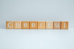 Wooden blocks form the text Cheerful against a white background. photo