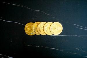 5 XRP coins XRP stacked on a black marble background. photo