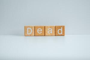 Wooden blocks form the text Dead against a white background. photo