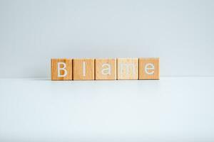 Wooden blocks form the text Blame against a white background. photo