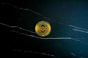 BNB coin on black marble texture. photo