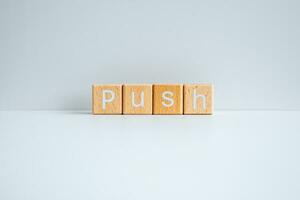 Wooden blocks form the text Push against a white background. photo
