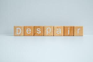 Wooden blocks form the text Despair against a white background. photo