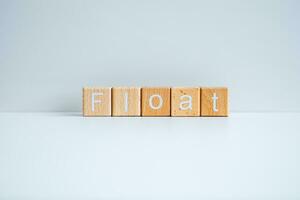 Wooden blocks form the text Float against a white background. photo