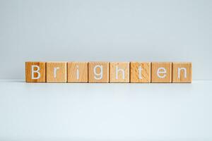 Wooden blocks form the text Brighten against a white background. photo