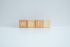 Wooden blocks form the text Warm against a white background. photo