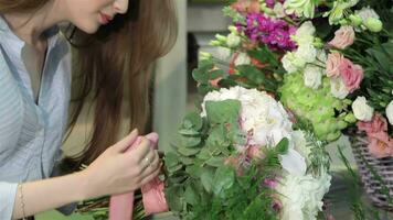 femelle fleuriste fait du une bouquet de fleurs à fleur magasin video